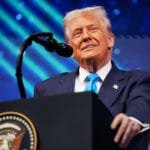 A photo of Donald Trump speaking at a live TV appearance.