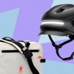 A person wearing a high-visibility jacket and riding a bike in the snow.