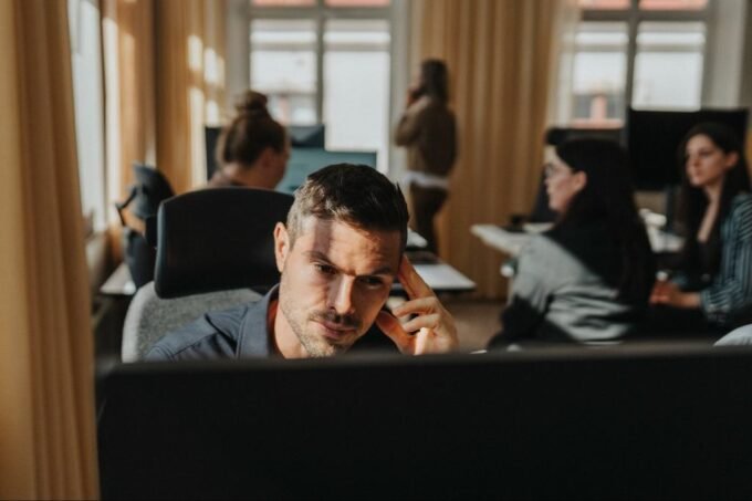 Entrepreneur looking at a declining graph, contemplating a strategic pivot with a calm, focused expression.