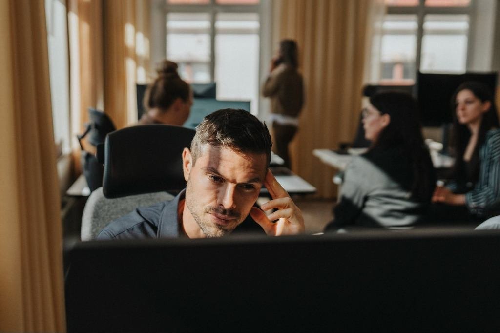 Entrepreneur looking at a declining graph, contemplating a strategic pivot with a calm, focused expression.