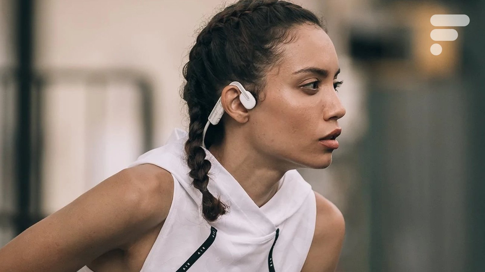 Casque Shokz OpenMove avec un sportif en train de courir sous la pluie.