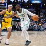 لاعب بوسطن سيلتيكس جايلن براون (7) وهو يراوغ بالكرة بينما يدافع عليه لاعب إنديانا بيسرز أندرو نيمبارد (2) في الشوط الثاني.