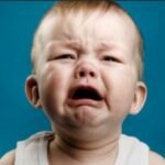 رضيع يحدق في شاشة هاتف ذكي، مع إظهار تأثيرات على نمو دماغه