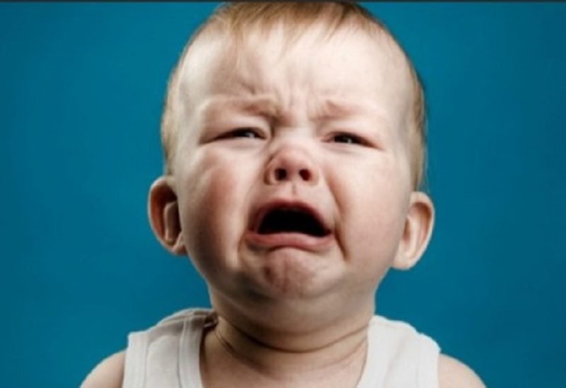 رضيع يحدق في شاشة هاتف ذكي، مع إظهار تأثيرات على نمو دماغه