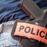 صورة لشرطي يحمل سلاحه الوظيفي.