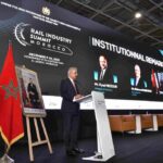 صورة لقطار يمر عبر سكة حديد في المغرب, مع خلفية لجبال الأطلس.