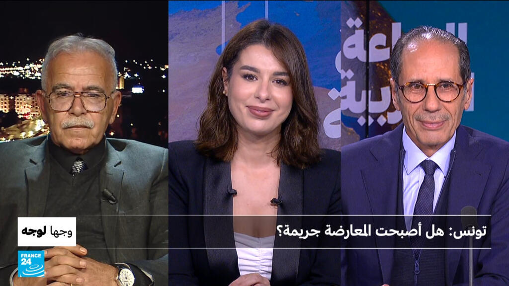 صورة لشخص يرفع علم تونس في وسط مدينة تونس العاصمة.