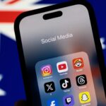 ** صورة لشاب يرتدي نظارات زجاجية ويستخدم هاتفًا.