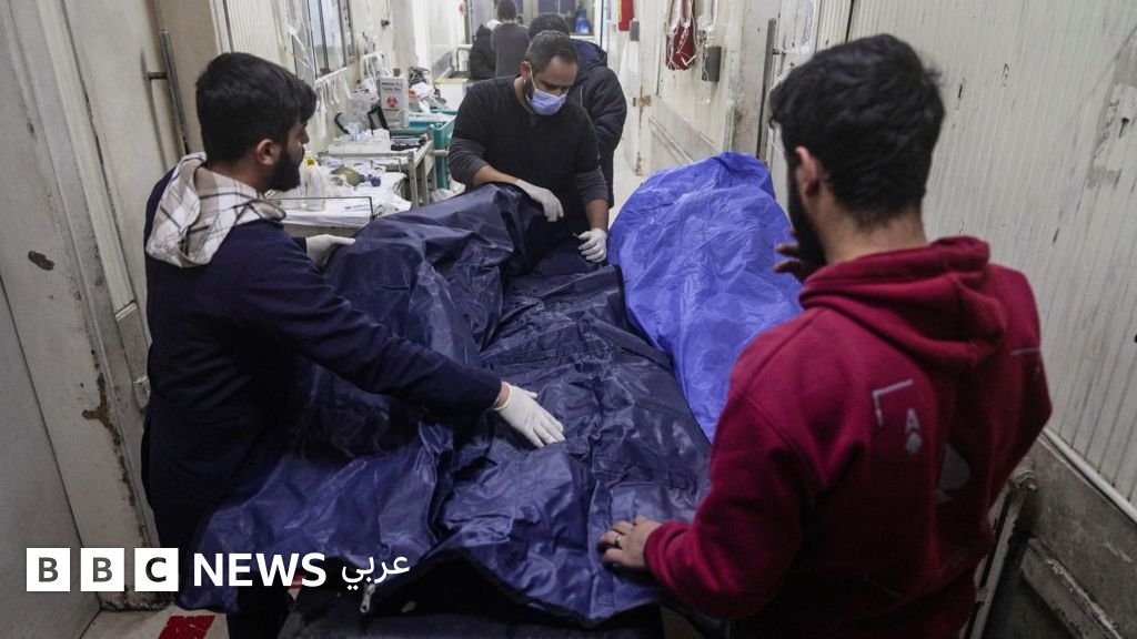 ** صورة مسعفون يضعون جثة في كيس مخصص للجثث في أحد المستشفيات خلال موجة هجمات شنّتها القوات الحكومية وقوات سوريا الديمقراطية بقيادة الأكراد في مدينة حلب شمال سوريا.