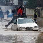 صورة لأطفال يغمرون في مياه الأمطار داخل مخيم نازحين في قطاع غزة.
