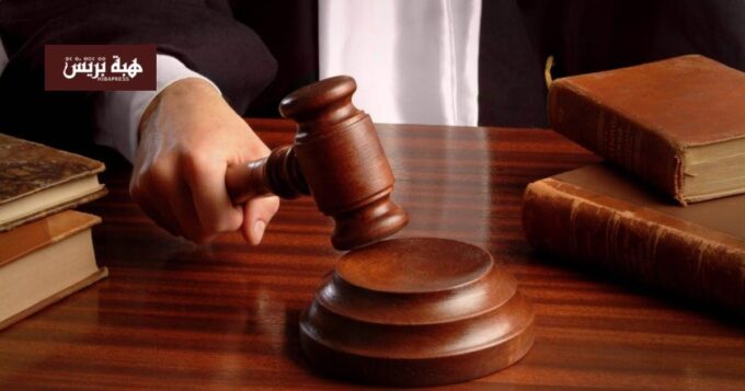 صورة لشخص يرتدي زي محامي ويشير إلى حكم المحكمة.