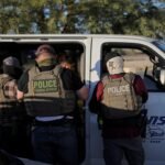 عملاء الهجرة والجمارك (ICE) يفحصون وثائق مجموعة من العمال الزراعيين في موقف للسيارات بولاية كاليفورنيا.