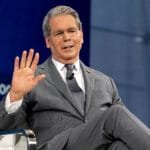 A photo of a financial market graph with a subtle background of a government building.