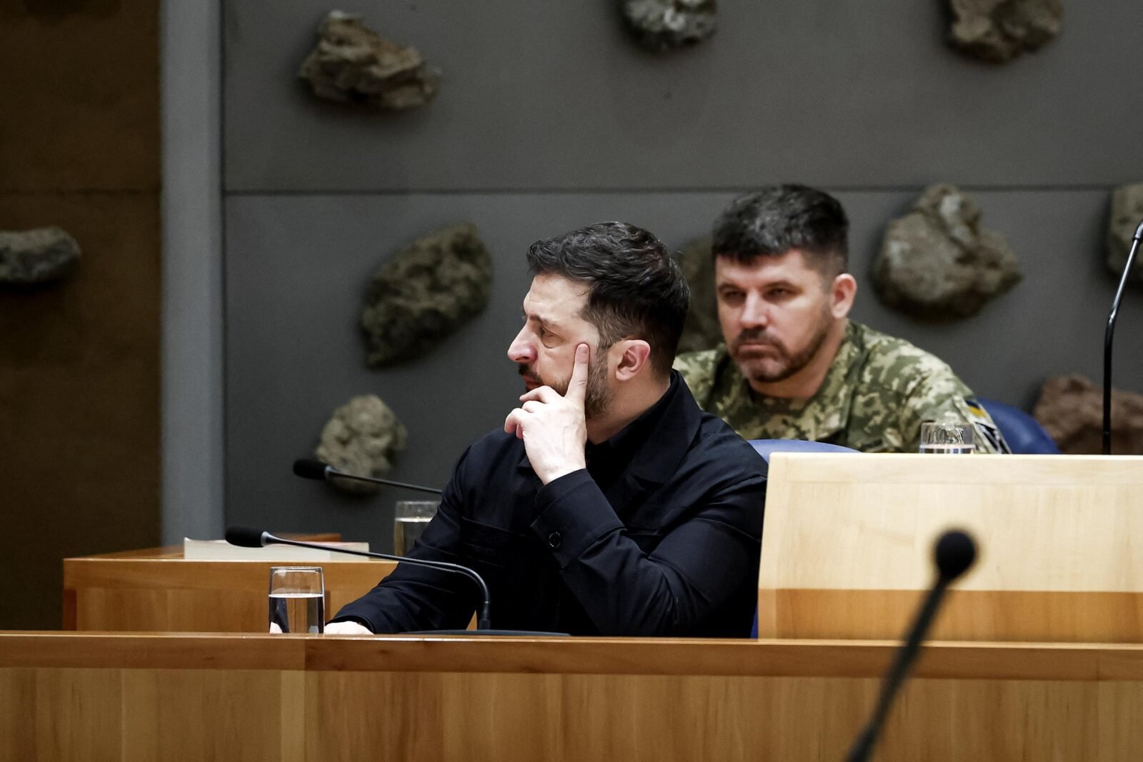 Un groupe de personnes regroupées autour d'un drapeau ukrainien, avec un texte alt "Guerre en Ukraine : Zelensky arrive au Canada pour une rencontre avec le premier ministre"