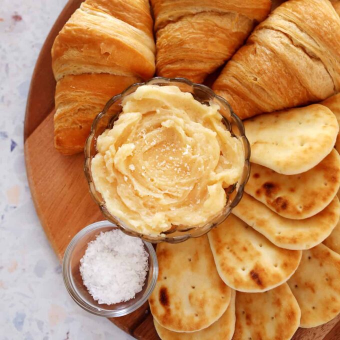 Honey butter on a butter board with rosemary and sea salt.
