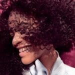 Jojoba oil bottle with hair in the background