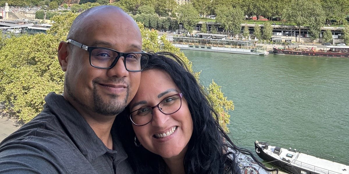 A couple sitting on a sofa, one reading quietly, the other engaged in conversation, symbolizing balance and compromise in a relationship.