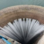 Un barrage en pleine eau, avec des pluies torrentielles en arrière-plan.