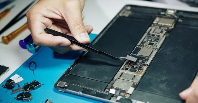 A group of people working together to repair a device.