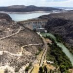 Alt text for the image: "US and Mexico leaders shaking hands, with the Rio Grande River in the background"