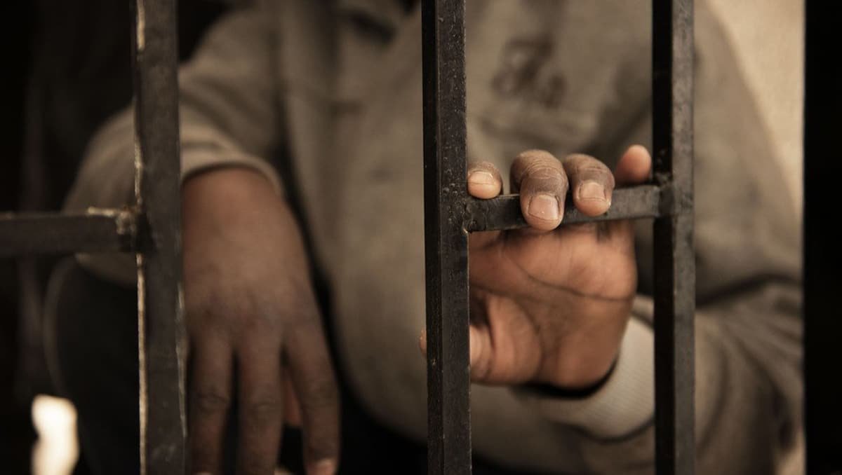 Les agents de police en train d'effectuer un examen médical à un détenu.