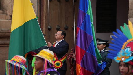 صورة لشخص يكتتب على الكمبيوتر مع خلفية من الكتب.