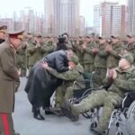 صورة كيم جونغ أون يعانق جنودًا جرحى.