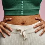 A person examining their skin in a mirror