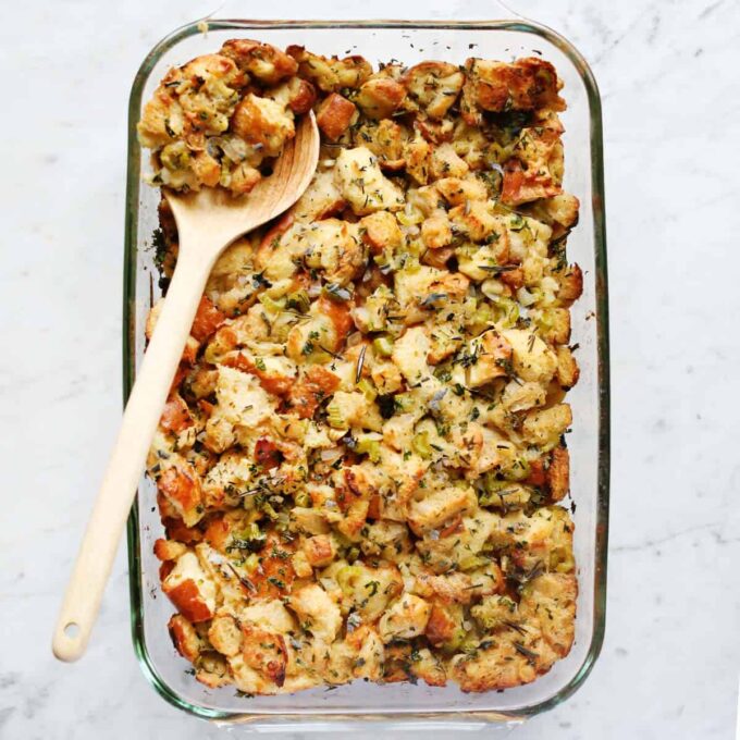 "A golden-brown stuffing dish with fresh herbs on top"