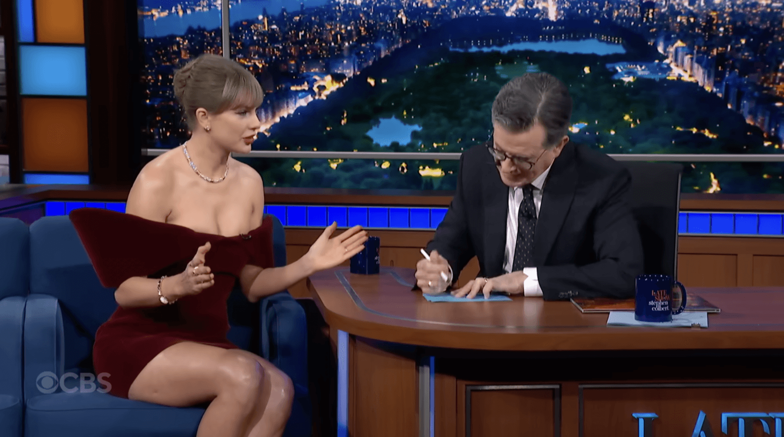 Taylor Swift and Stephen Colbert brainstorming a mystery novel together