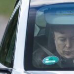 A Tesla vehicle parked in front of a factory, symbolizing the company's production and market strategy.