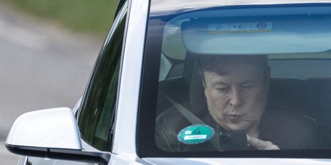 A Tesla vehicle parked in front of a factory, symbolizing the company's production and market strategy.