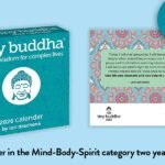 A colorful Tiny Buddha day-to-day calendar on a desk, open to an inspiring quote.