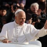 Un groupe de personnes de différentes cultures et religions se tenant la main et souriant, avec un arrière-plan de la nuit de Noël.