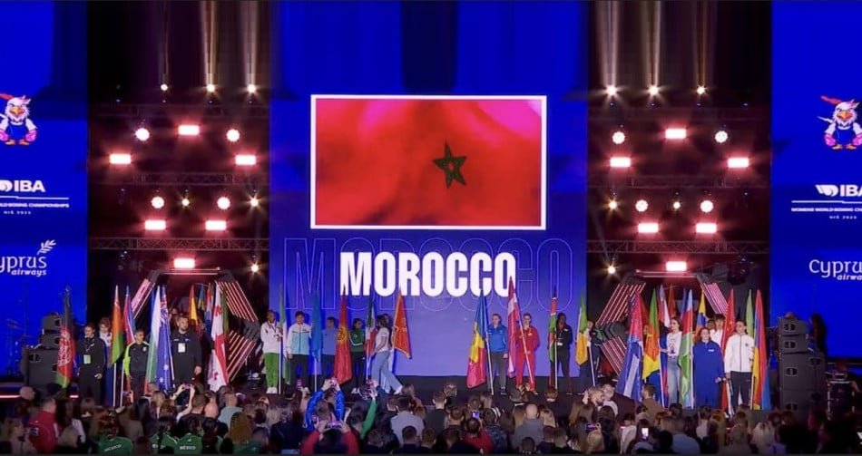 Description of the image in English: A photo of a boxer in action, with a Moroccan flag in the background.