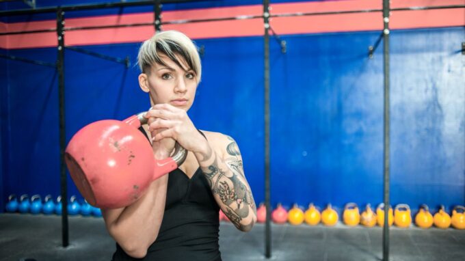 Alt text for the image: "Vegetarian bodybuilder in the gym, with a protein shake and a plate of healthy food"
