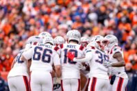 New England Patriots and Seattle Seahawks helmets facing off on a football field, representing Super Bowl LX 2026