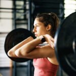 A person lifting weights in a gym, demonstrating strength training efficiency.