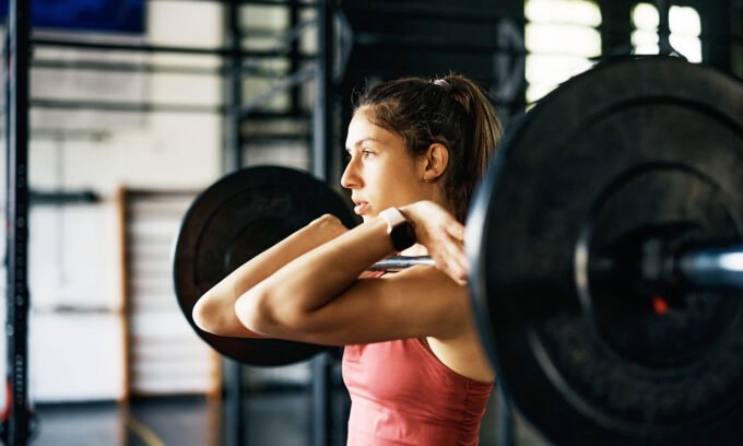 A person lifting weights in a gym, demonstrating strength training efficiency.