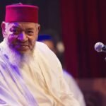 Portrait en noir et blanc d'Abdelhadi Belkhayat, le chanteur marocain, souriant et regardant au loin.