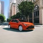 A diverse lineup of affordable new cars recommended by Consumer Reports, parked on a modern city street.