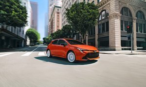 A diverse lineup of affordable new cars recommended by Consumer Reports, parked on a modern city street.