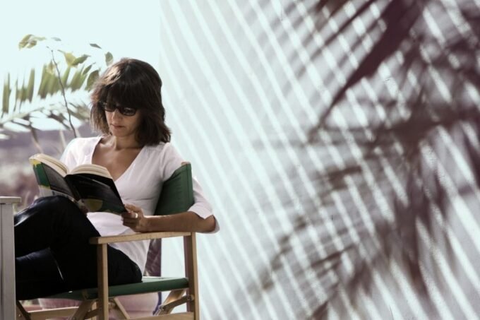 A person meditating or reading a physical book in a serene, natural setting, with subtle digital elements in the background, symbolizing the harmonious integration of human practices and AI technology.