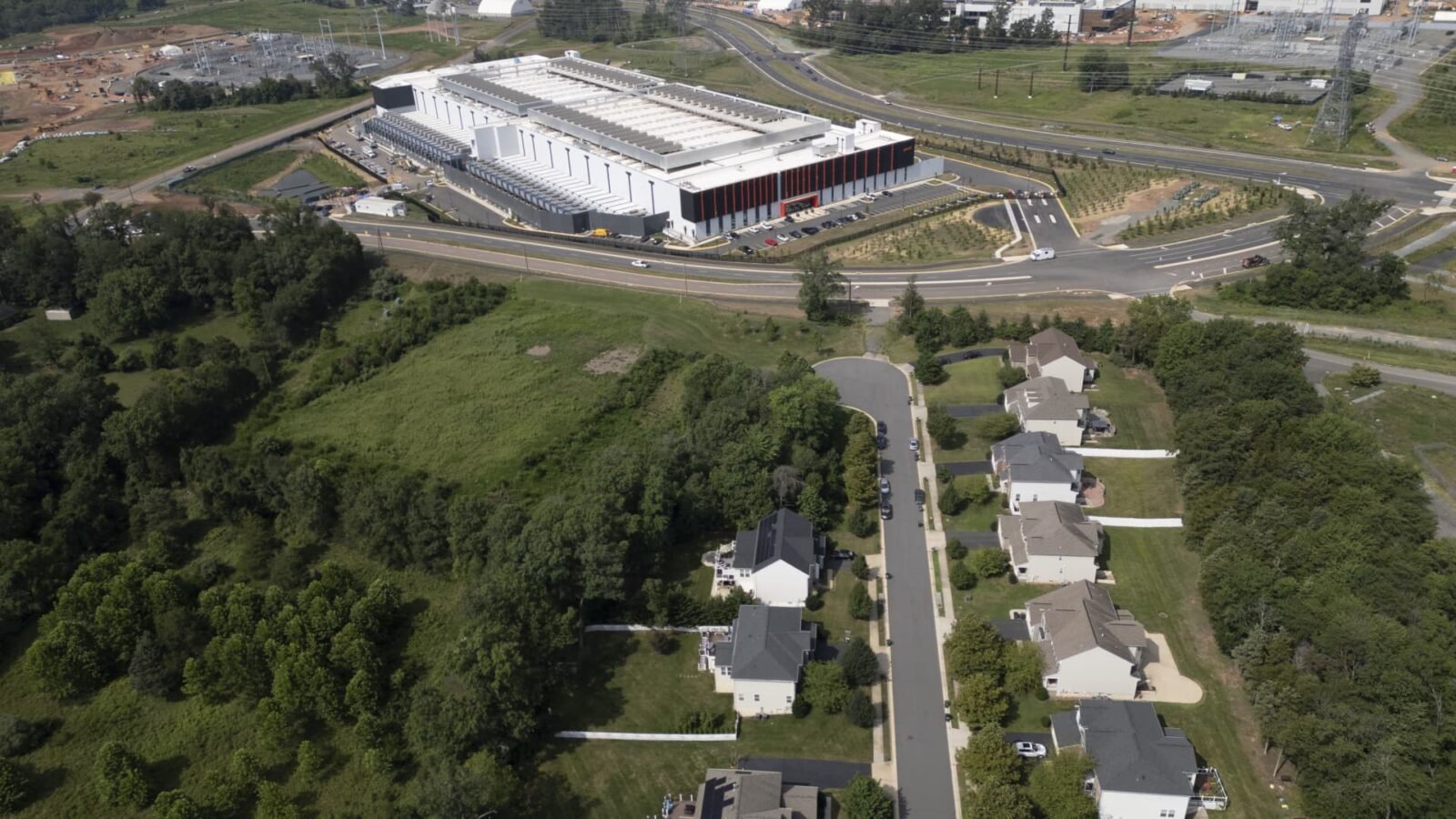 Senator Bernie Sanders and Governor Ron DeSantis, representing opposing political views, stand together against a backdrop of data center infrastructure, symbolizing their unexpected alliance against the AI industry's energy demands.