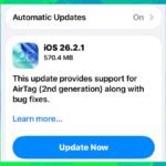 An iPhone screen displaying the iOS 26.2.1 software update notification, with an Apple AirTag 2 in the foreground.