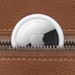 A four-pack of Apple AirTags displayed with one AirTag detached, highlighting its compact and sleek design.