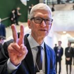 Apple CEO Tim Cook gestures at the World Economic Forum, discussing business leaders reception.