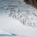 Drame au Toubkal : Une Avalanche Emporte Trois Personnes, Vastes Recherches en Cours 4 Vue aérienne du mont Toubkal enneigé avec des traces d'avalanche, des équipes de secours en action.