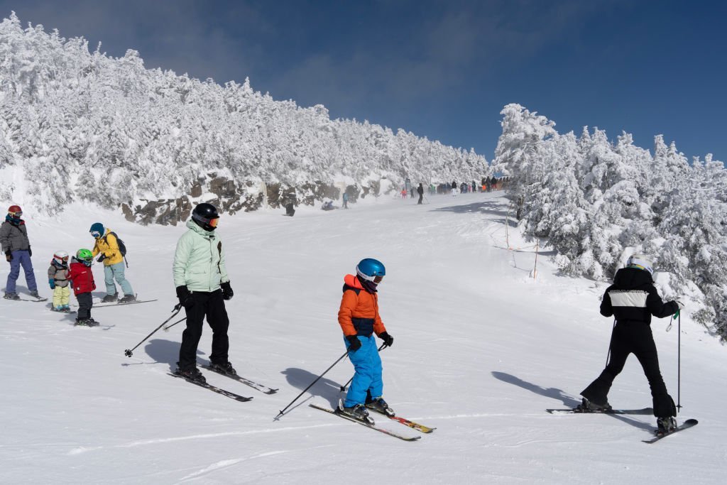 A general view of a bustling ski resort with snow-covered mountains and skiers.