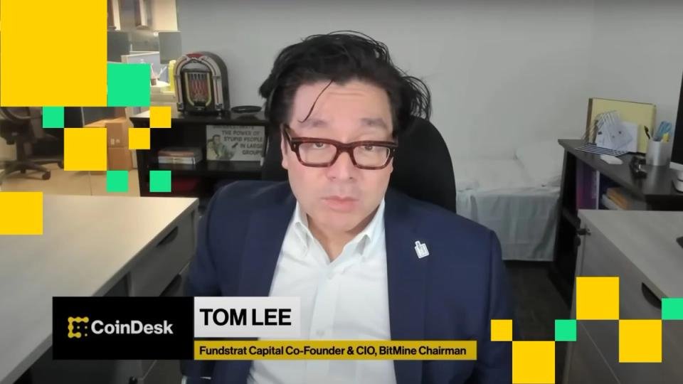 Tom Lee speaking at a financial conference, with a stylized Ethereum logo in the background.